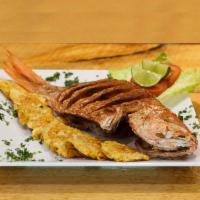 Pargo Rojo Frito · Fried red snapper served with salad, yellow rice and fried green plantains.