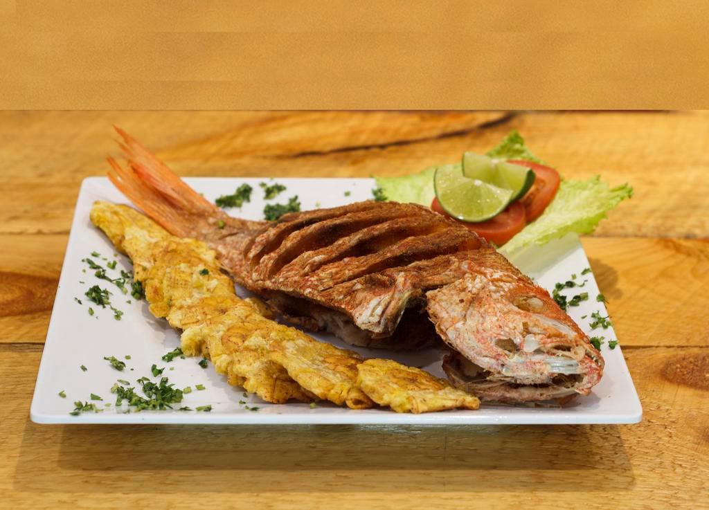 Pargo Rojo Frito · Fried red snapper served with salad, yellow rice and fried green plantains.