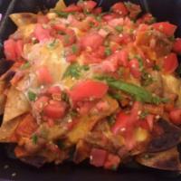 Nachos · Crispy corn chips, topped with refried beans, melted cheddar cheese, california red chile sa...