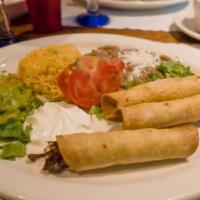 Taquitos Con Guacamole · 3 hand rolled crispy corn tortillas filled with beef, chicken or potato served with sour cre...
