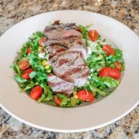 Tuscan Steak Salad · Wild arugula, chip marinated tomato, grilled skirt streak, roasted corn, cucumbers and Gorgo...