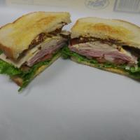 Luna Melt Sandwich · Grilled sourdough, ham, turkey, bacon, provolone, mayo, mustard, chipotle sauce, lettuce, to...
