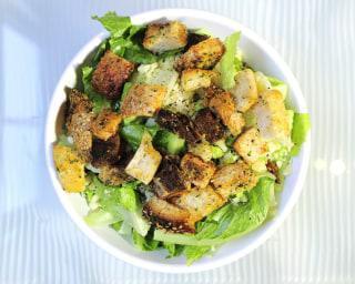 Founders Classic Caesar Salad · Chopped romaine lettuce, Italian radicchio lettuce, anchovy free Caesar dressing, ground black pepper, shaved parmesan cheese, and garlic and herb croutons.