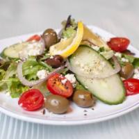 The Greek Salad · Cucumber, feta cheese, Greek olives, red onion, lemon wedge, and grape tomatoes with mesclun...