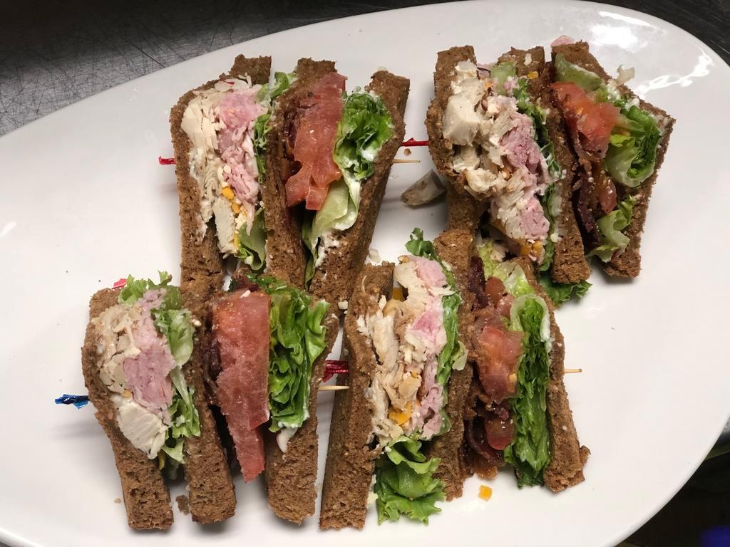 Range Club Lunch · Layers of sliced turkey tenderloin, ham, bacon, lettuce, tomato and aged yellow and white cheddar on toasted multi grain bread topped with our range mayo. Includes choice of side.