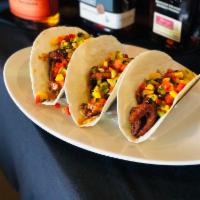 Blackened Salmon Tacos  · Three tacos filled with blackened salmon, with an Asian barbecue glaze, mango salsa, and sri...