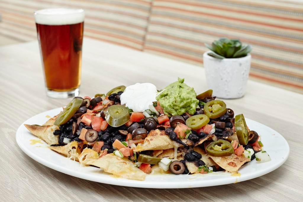 Nachos · House-made chips, cheddar, and Jack cheeses, pico de gallo, guacamole, sour cream, olives, jalapenos. Add steak, chicken or carnitas for an additional charge.