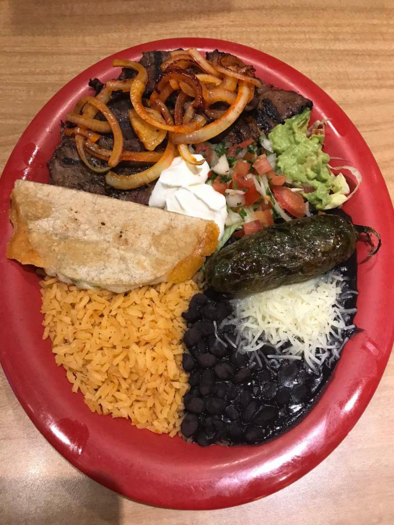Carne Asada Plate · Carne asada served with rice, beans, sour cream, guacamole, lettuce and two tortillas of choice on the side.