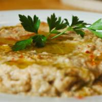 Baba Ghanouj · Fire-roasted eggplant blended with tahini, spices, and garlic served with pita bread.