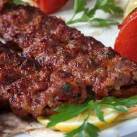Adana Kabab · 2 skewers of charbroiled hand-chopped beef and lamb seasoned with spicy red peppers and spec...