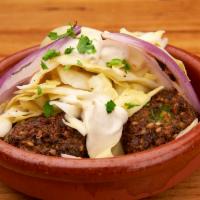 The Falafel · Falafel balls made from greens and chickpeas with tahini, cured cabbage and grilled onion. V...