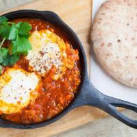 Classic Shakshuka · Mediterranean tomatoes and pepper stew, 2 eggs over easy. 
Served with Moroccan Frena Bread