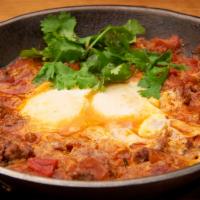 Shakshuka Senya · Mediterranean tomatoes and ground beef stew. Served with 2 eggs over easy. 
Served with Moro...