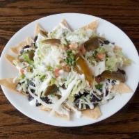 Nachos · Nacho tortilla, beans, meat, oaxaca cheese, lettuce, tomato, pico de gallo, cotija cheese an...