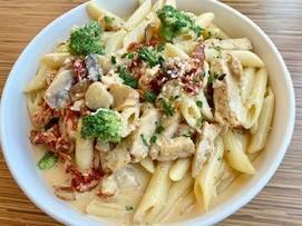 63. Roasted Garlic Penne · Penne pasta, grilled chicken, sun dried tomatoes, broccoli, mushrooms in roasted garlic cream sauce, topped with parmesan cheese 