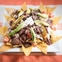 Nachos · Served with beef, beans, tomato, cheese and cream.