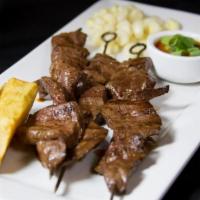 Anticuchos · Beef hearts skewers marinated in panca sauce and Peruvian spices served with Peruvian corn a...