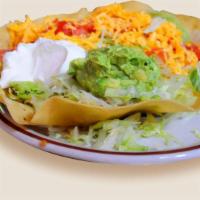 Tostada Grande · A crispy flour tortilla shell filled with seasoned ground beef, refried beans, lettuce, toma...