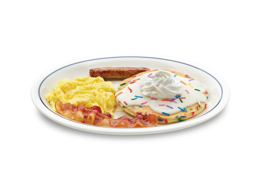 Jr. Cupcake Pancake Combo · One fluffy buttermilk pancake filled with festive rainbow sprinkles. Topped with cupcake icing & crowned with  whipped topping. Served with 1 scrambled egg, 1 custom-cured hickory-smoked bacon strip & 1 pork sausage link.