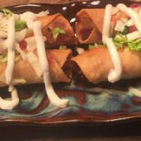 Flautas de Pollo · 4 crispy corn tortilla filled with shredded chicken, Monterey Jack cheese topped with lettuc...