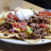 Taco Salad · Ground beef, ranchero sauce, avocado, on a bed of lettuce and tortilla chips. Topped with so...