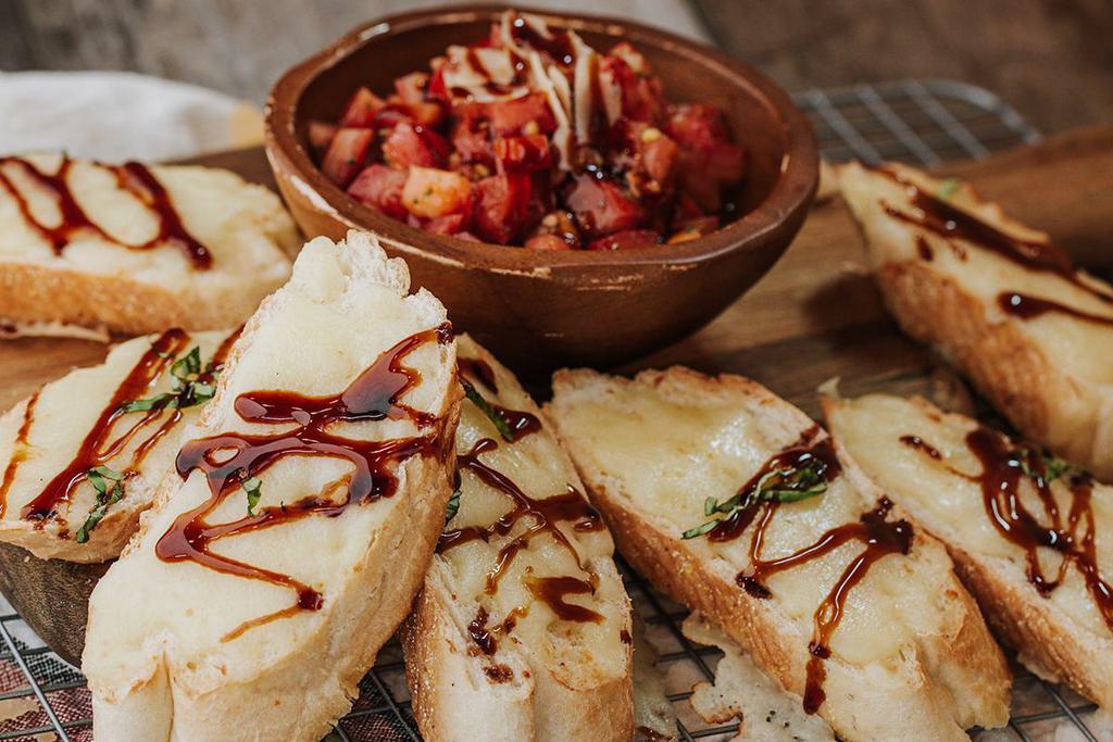 BRUSCHETTA · Garlicky toasted baguette, tomatoes, fresh basil, mozzarella, balsamic drizzle.
