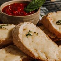 CHEESY GARLIC BREAD · Toasted French baguette, roasted garlic oil, mozzarella, fresh basil, signature red sauce.