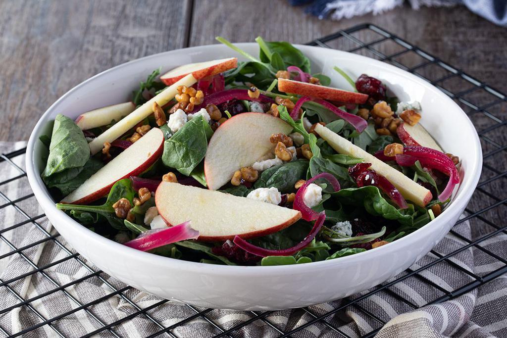 MAGNIFICENT GREEN · Spinach, bleu cheese crumbles, sliced apples, dried cranberries, pickled red onions, candied walnuts, tossed in lemon vinaigrette.