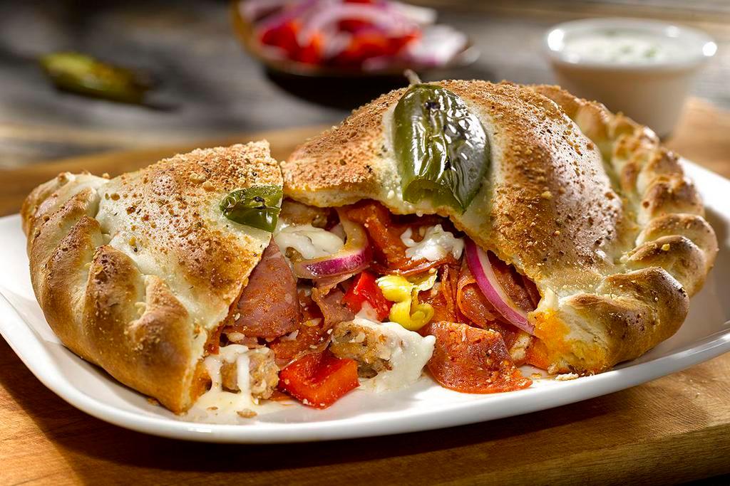 CHICAGO FIRE CALZONE · Pepperoni, salami, sweet Italian sausage, red peppers, red onions, pepperoncini, mozzarella, ricotta. Topped with a fresh jalapeño baked into the crust. Served with house-made ranch.