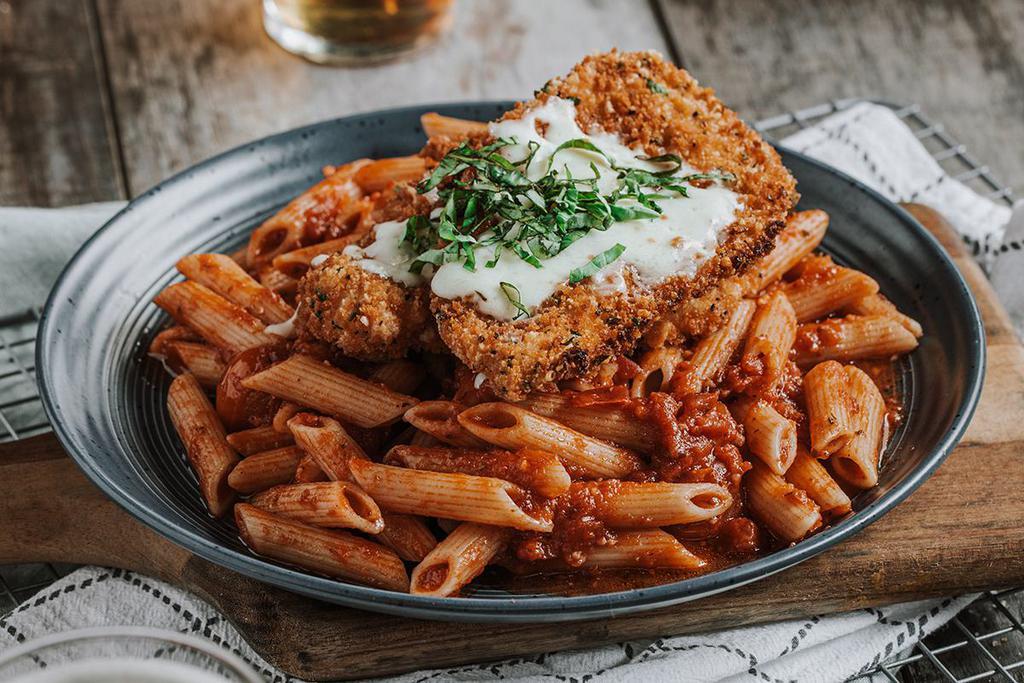 CHICKEN PARMESAN  · Basil-parmesan crusted chicken breast, mozzarella, penne, blistered tomatoes, fresh basil & signature red sauce.