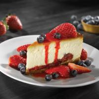 CHEESECAKE WITH FRESH BERRIES · New York-style cheesecake on a graham cracker crust, fresh strawberries & blueberries, drizz...