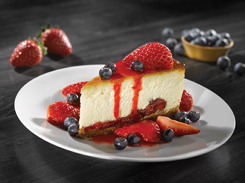CHEESECAKE WITH FRESH BERRIES · New York-style cheesecake on a graham cracker crust, fresh strawberries & blueberries, drizzled with strawberry sauce. 