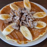 Caramel Banana Pancakes · Pancakes filled with banana, topped with banana house made sugared pecans and caramel. Duste...