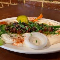 Merguez Hummus Plate · Homemade lamb and beef sausages, seasons with Middle Eastern spices, topped with roasted alm...