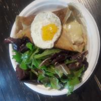 CP9. La Complete Madame Crepe · Crepe with bechamel sauce, parisian ham Swiss cheese and Sunny Side Up egg. Served with a si...