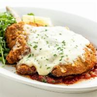 Veal Chop alla Taormina · Breaded veal chop with melted mozzarella cheese on a bed of sautéed tomato sauce and arugula.