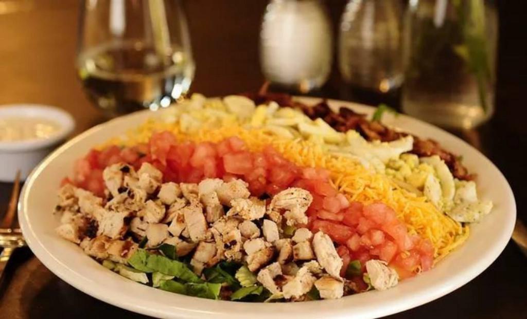 Cobb Salad · Bed of mixed greens, topped with grilled chicken, bacon, cheddar, hard boiled egg, diced tomato, served with house ice box buttermilk dressing.