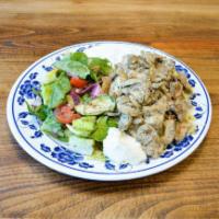 18. Chicken Shawarma · Slices of grilled chicken shawarma served with rice pilaf, salad, tzatziki, and garlic sauce.