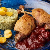 Duck Confit · 2 duck legs, under cherry sauce, served with rice.