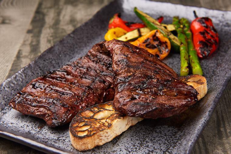 Grilled Skirt Steak · Marinated whole skirt steak, grilled to your taste, served with vegetables.