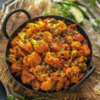 Aloo Matar Gobhi · Garden fresh potatoes, baby field peas, cauliflower simmered in an onion & tomato sauce. Acc...