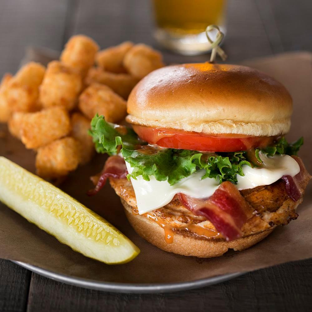 Chipotle Chicken Sandwich · Grilled white wheat beer-brined chicken breast with apple wood smoked bacon, Swiss cheese and chipotle sauce, served on a toasty brioche bun.