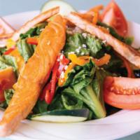 Grilled Salmon Salad · Crisp romaine, Roma tomato and cucumber, feta cheese, thinly sliced sweet peppers, topped wi...