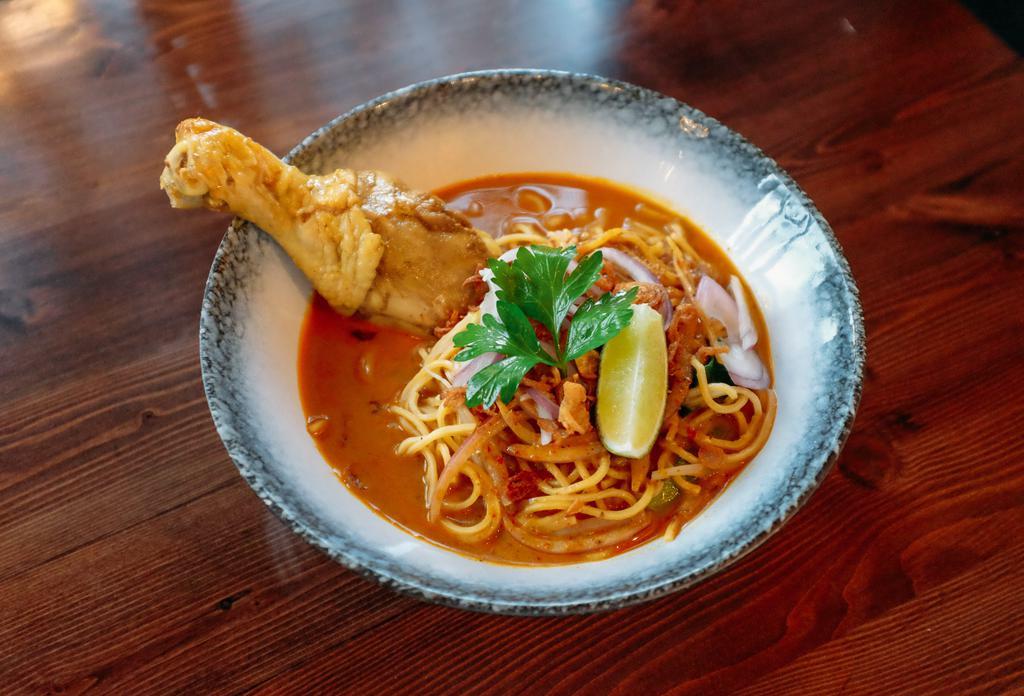 Noodle Curry Soup (Khao Soi) · A dish with chicken, bok choy, bean sprouts and egg noodle topped with fried onion.