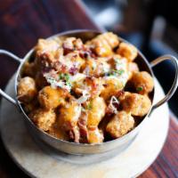 Loaded Tots · Tater tots, hollandaise sauce, cheddar cheese, bacon, green onions.