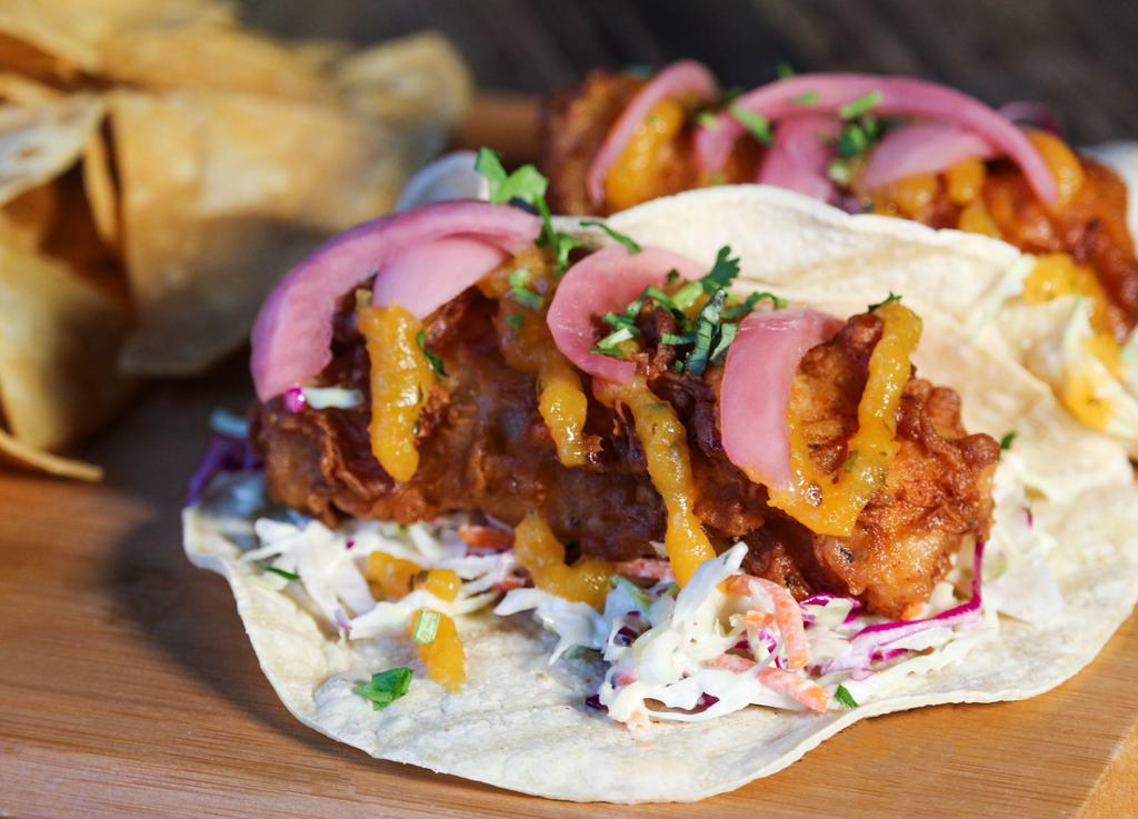 Mango Habanero Fish Tacos · Beer-battered cod, mango habanero sauce, coleslaw, pickled red onion, cilantro, corn tortilla, side of chips and roasted tomato salsa.