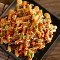 Asian Style Fries · Crispy beer-battered fries, topped with ranch, spicy ranch, Sriracha, green onions, bacon bi...