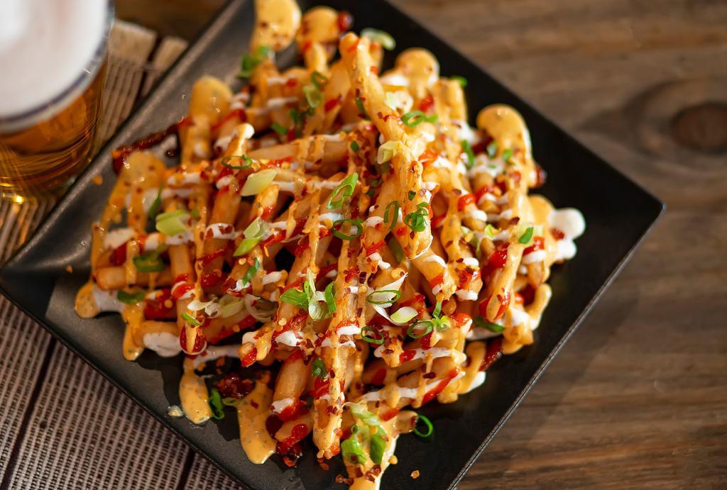 Asian Style Fries · Crispy beer-battered fries, topped with ranch, spicy ranch, Sriracha, green onions, bacon bits and chili flakes.