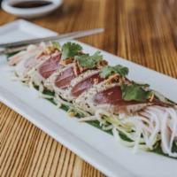 Tuna Tataki · Seared tuna sashimi over a bed of cucumber with krab stick, crispy onions, and citrus soy-se...