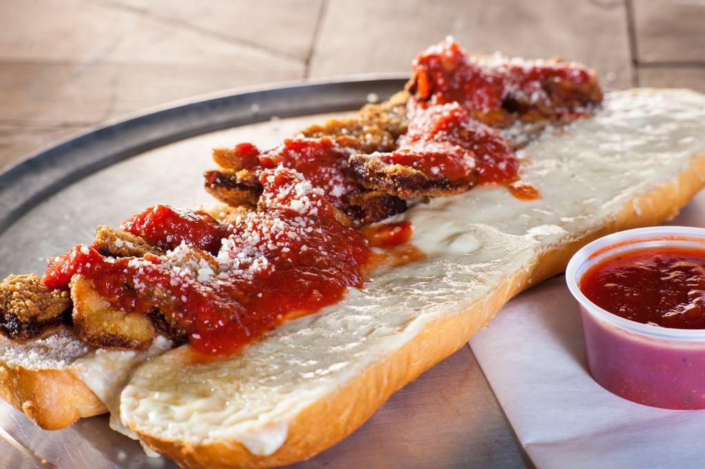 Eggplant Parmigiana Hero · Our fresh Italian hero roll stuffed with breaded eggplant, blanketed with mozzarella cheese, baked in our brick oven.  Served with marinara sauce evenly spread on top.  Consider adding sauteed mushrooms, onions or bell peppers for an additional charge. 